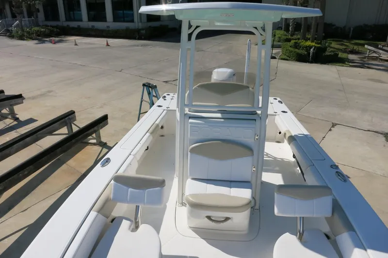 Slide: The Image of 2018 Robalo 246 Cayman boat interior with seating and console, docked outdoors. - 25