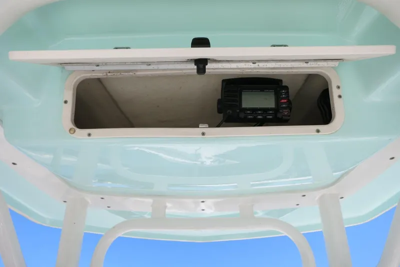 Slide: The Image of 2018 Robalo 246 Cayman boat storage compartment with electronic device inside. - 28