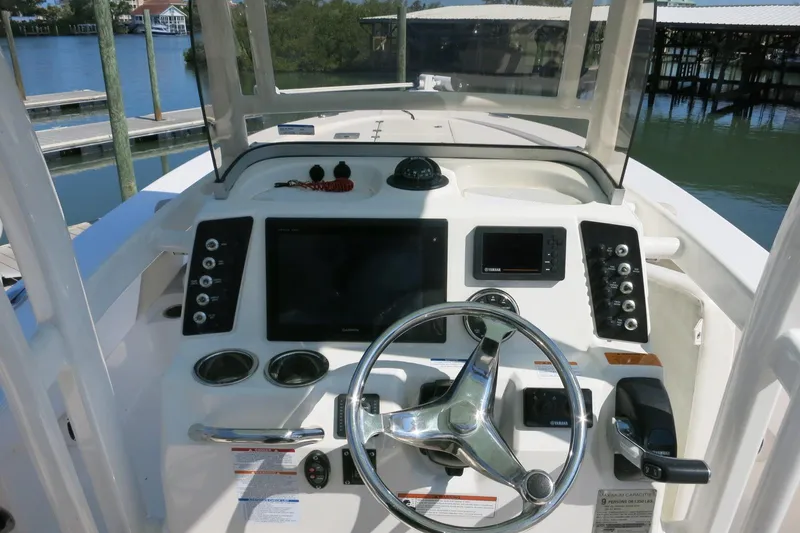 Slide: The Image of 2018 Robalo 246 Cayman boat dashboard with steering wheel and navigation controls. - 29
