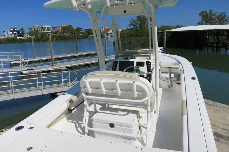 Slide: The Image of 2018 Robalo 246 Cayman boat docked by a serene waterfront with clear blue skies. - 7