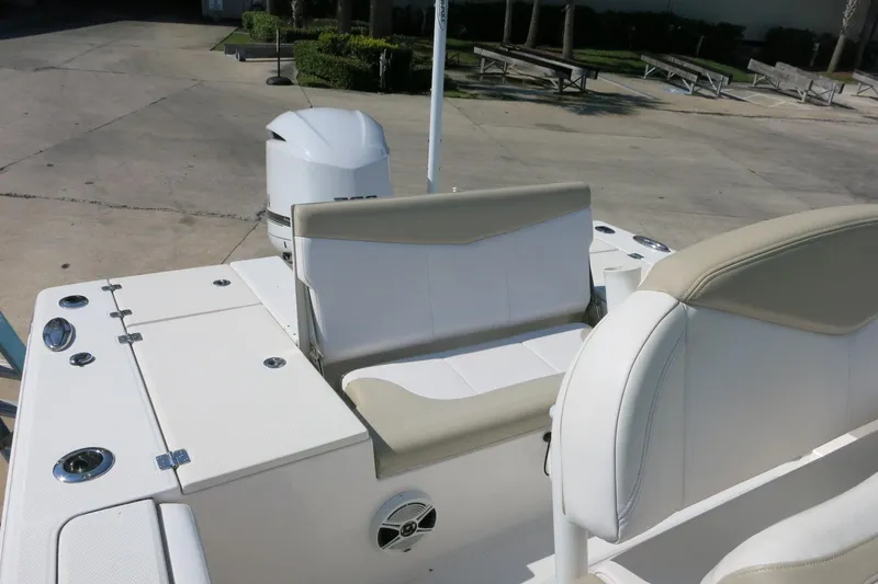 Slide: The Image of 2018 Robalo 246 Cayman boat interior with seating and motor, docked outdoors. - 9