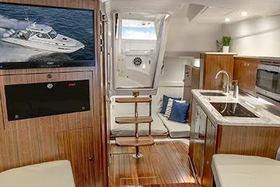 Slide: The Image of 2026 Pursuit OS 355 Offshore yacht interior with modern kitchen and cozy seating area. - 11