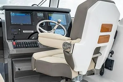 Slide: The Image of 2026 Pursuit OS 355 Offshore helm with modern controls and comfortable captain's chair. - 8