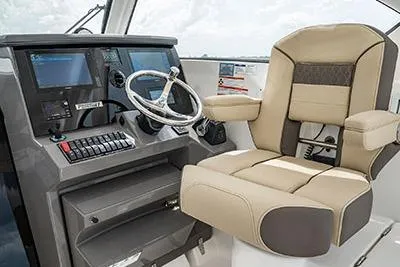 Slide: The Image of 2026 Pursuit OS 355 Offshore helm with modern controls and comfortable captain's chair. - 9