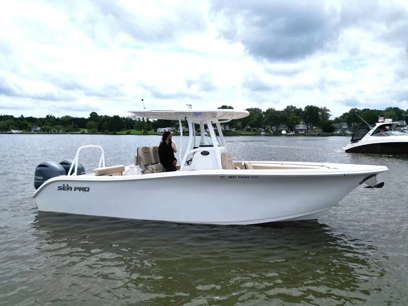 The Image of 2023 Sea Pro 259 DLX boat on calm water under cloudy sky. - 1