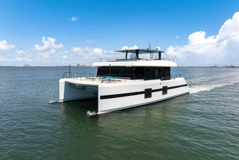 Slide: The Image of 2018 Sunreef 68 Supreme yacht cruising on open water under a clear blue sky. - 2