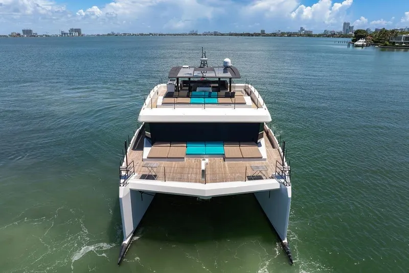 Slide: The Image of 2018 Sunreef 68 Supreme yacht on calm waters, showcasing luxurious deck and seating. - 3