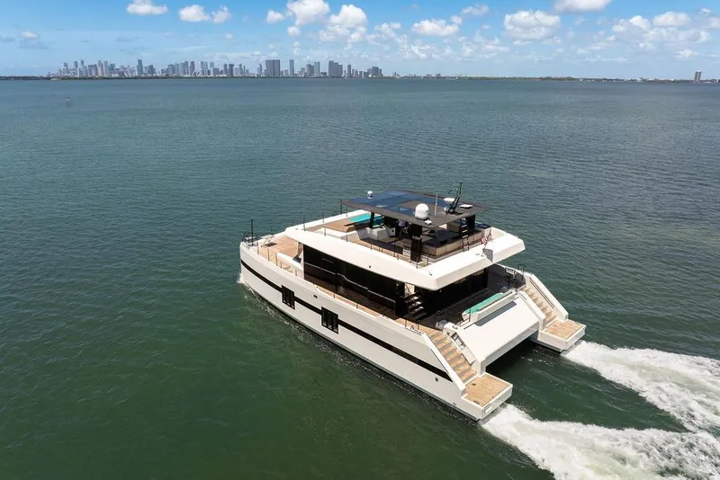 Slide: The Image of Luxurious 2018 Sunreef 68 Supreme yacht cruising on open water with city skyline backdrop. - 5