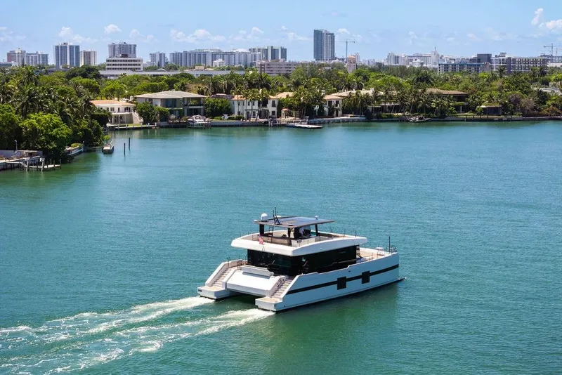 Slide: The Image of Sunreef 68 Supreme 2018 yacht cruising in a scenic waterfront cityscape. - 6