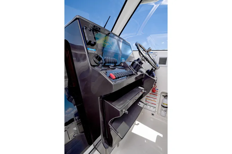 Slide: The Image of Helm of 2026 Pursuit OS 325 Offshore boat with modern controls and steering wheel. - 15