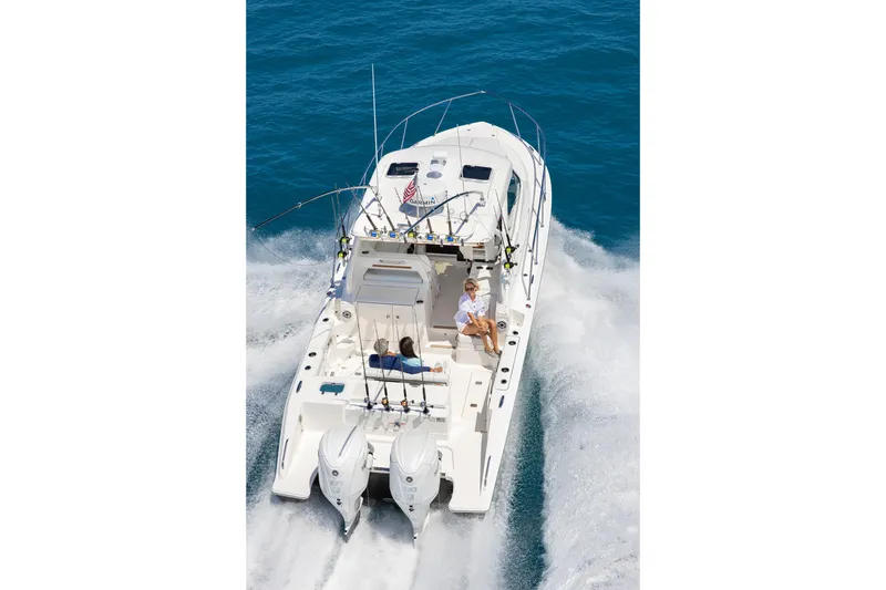 Slide: The Image of 2026 Pursuit OS 325 Offshore boat cruising on open water, featuring dual engines. - 3