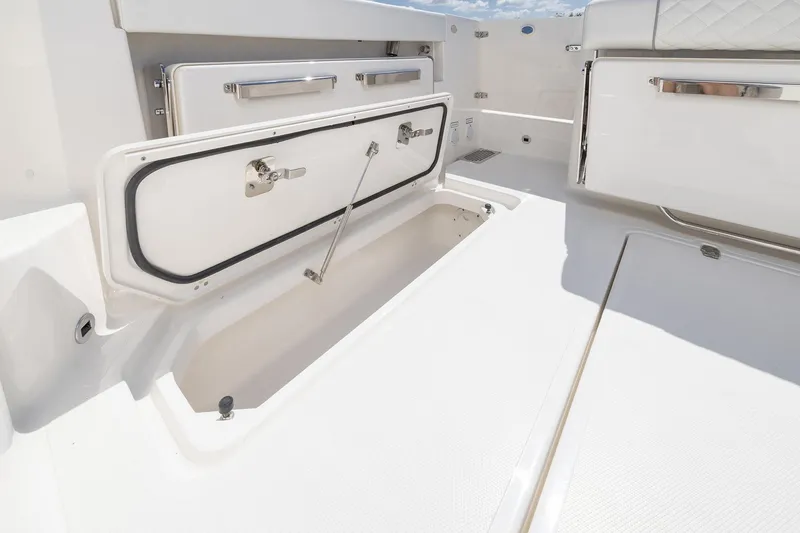 Slide: The Image of 2026 Pursuit OS 325 Offshore boat storage compartment with open hatch. - 7