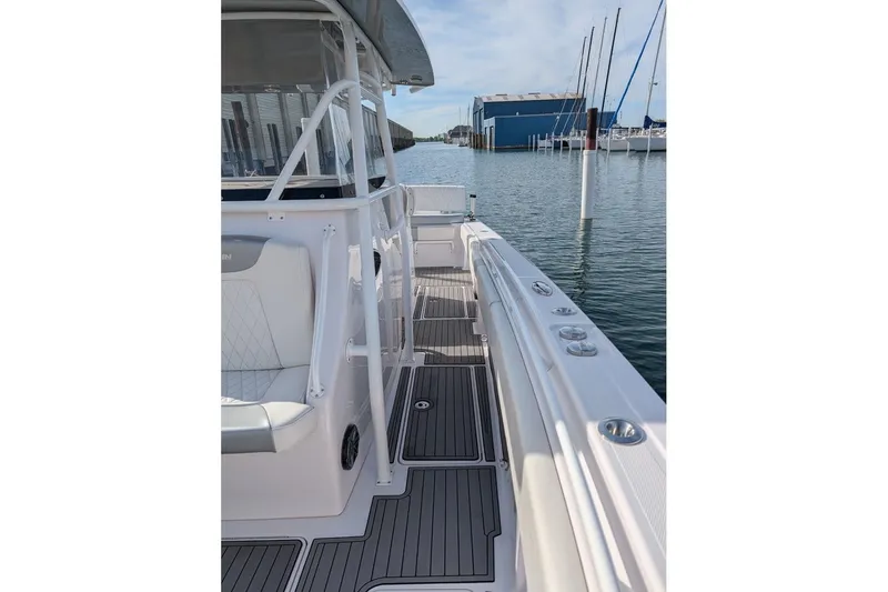 Slide: The Image of 2018 Fountain 38 Center Console boat docked, showcasing sleek design and spacious deck. - 10