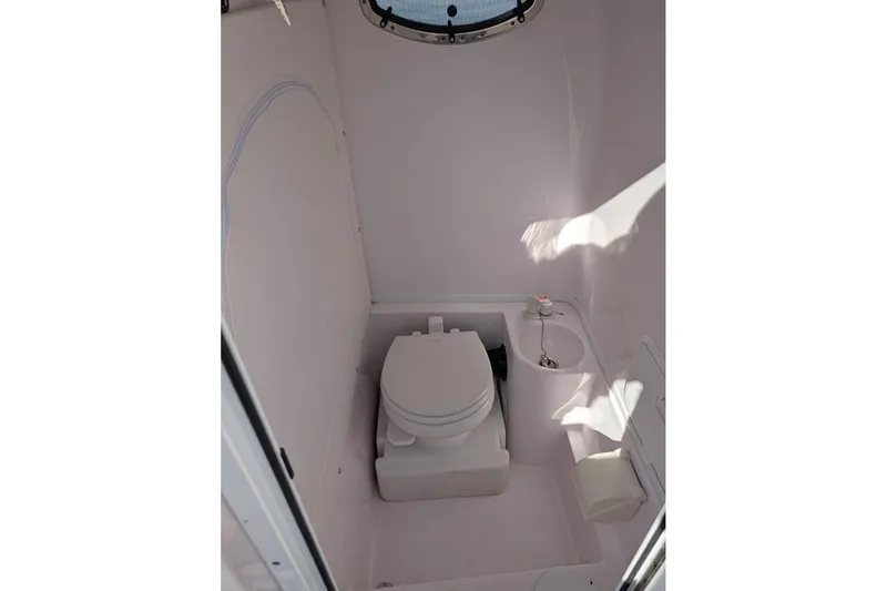 Slide: The Image of 2018 Fountain 38 Center Console boat bathroom interior with toilet and sink. - 18