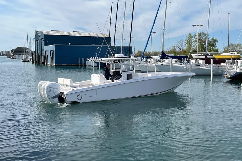 Slide: The Image of 2018 Fountain 38 Center Console boat docked in a marina with blue buildings. - 2