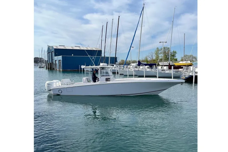 Slide: The Image of 2018 Fountain 38 Center Console boat docked in marina with sailboats. - 3