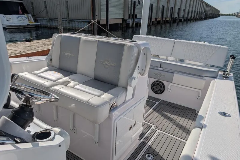 Slide: The Image of 2018 Fountain 38 Center Console boat interior with cushioned seating and steering wheel. - 6