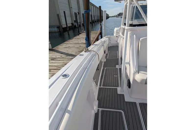 Slide: The Image of 2018 Fountain 38 Center Console boat docked, showcasing sleek deck design and modern features. - 9