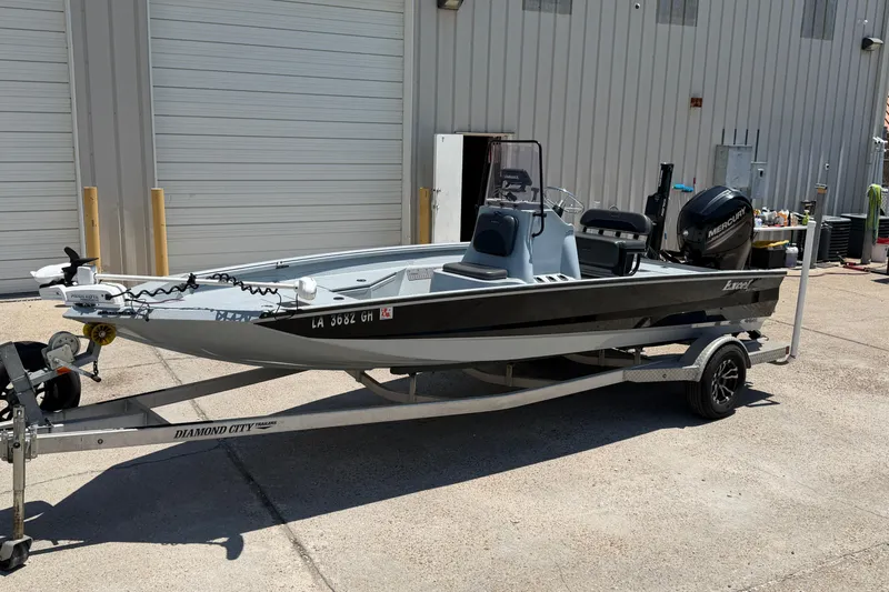 The Image of 2018 Excel 203 Bay Pro boat on trailer, parked outside a garage. - 1