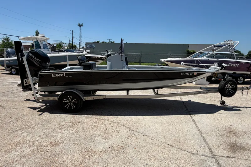 Slide: The Image of 2018 Excel 203 Bay Pro boat on trailer, parked outdoors under clear sky. - 6