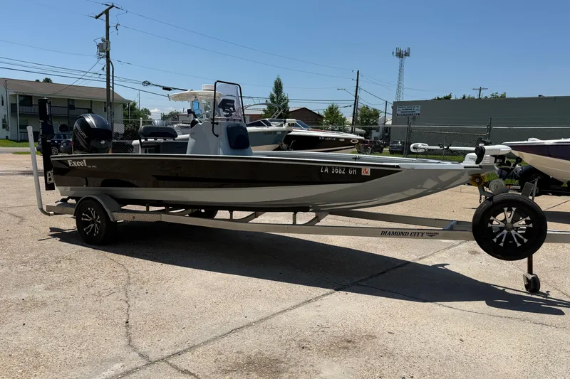 Slide: The Image of 2018 Excel 203 Bay Pro boat on trailer in parking lot, side view. - 7