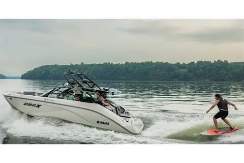 Slide: The Image of 2026 Yamaha Boats 222XD on a lake with a person wakesurfing nearby. - 13