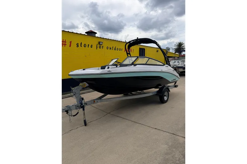 Slide: The Image of 2026 Yamaha AR195 boat on trailer in front of yellow building. - 3