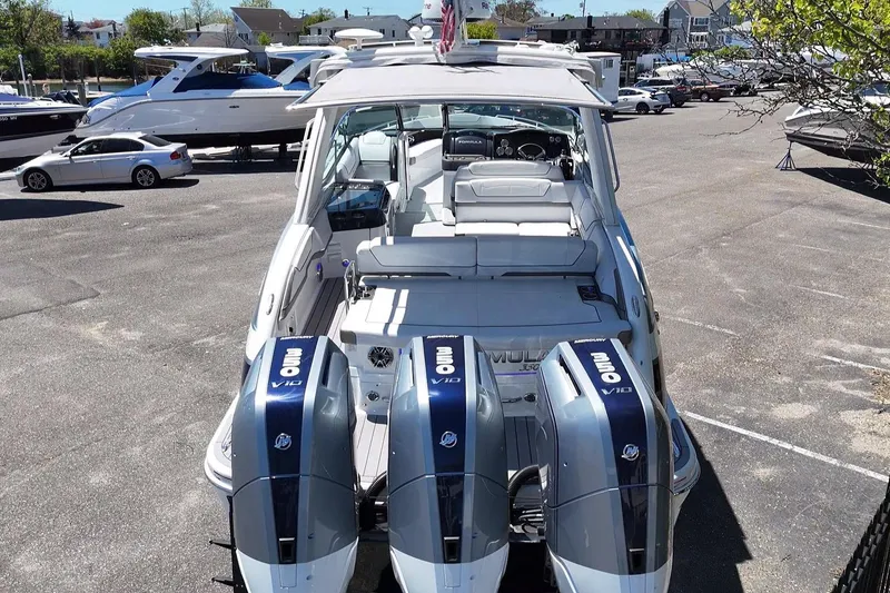 Slide: The Image of 2023 Formula 350 Crossover Bowrider OB with triple Mercury V10 outboard engines in a marina. - 12
