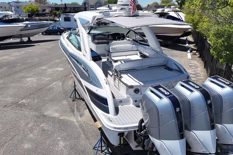 Slide: The Image of 2023 Formula 350 Crossover Bowrider OB with triple outboard engines, docked outdoors. - 13