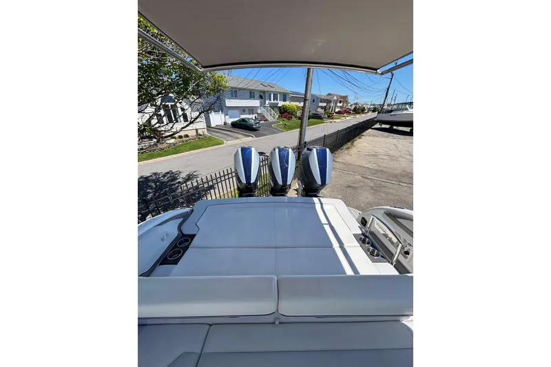 Slide: The Image of 2023 Formula 350 Crossover Bowrider OB with triple outboard engines, docked in a residential area. - 16