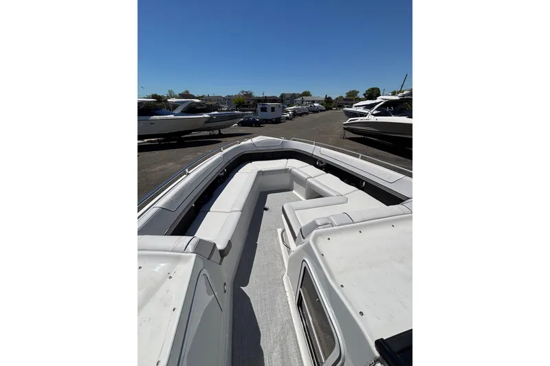 Slide: The Image of 2023 Formula 350 Crossover Bowrider OB with spacious seating, docked under clear skies. - 31
