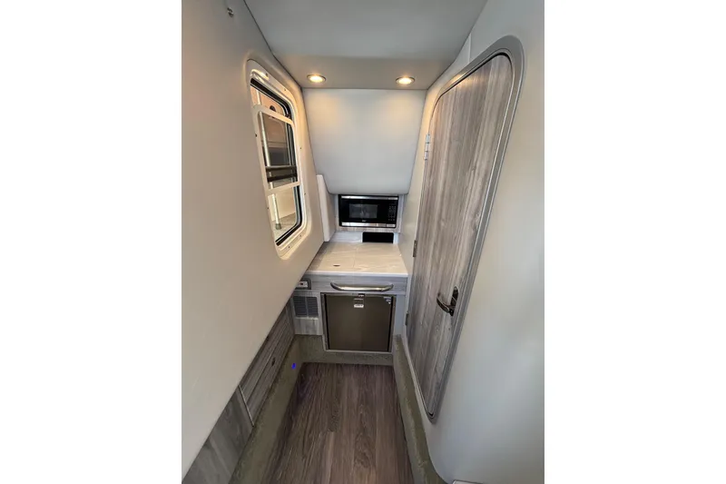 Slide: The Image of Interior of 2023 Formula 350 Crossover Bowrider OB, featuring compact kitchenette and modern design. - 35