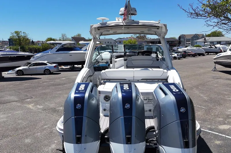 Slide: The Image of 2023 Formula 350 Crossover Bowrider OB with triple outboard engines in a marina setting. - 4