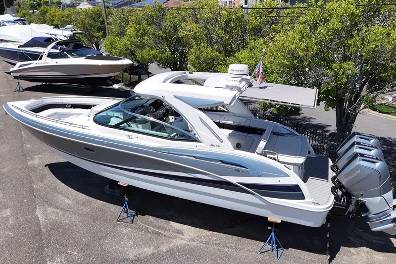 Slide: The Image of 2023 Formula 350 Crossover Bowrider OB with triple Mercury outboards, parked on stands. - 9