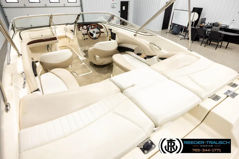 Slide: The Image of 2007 Glastron GXL 205 boat interior with beige seating and steering wheel in showroom. - 11