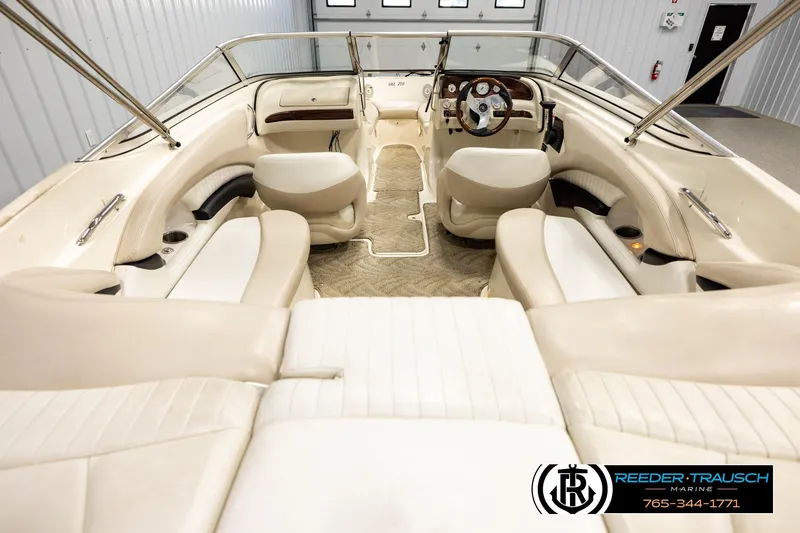 Slide: The Image of 2007 Glastron GXL 205 boat interior with beige seating and steering wheel, showcased indoors. - 13