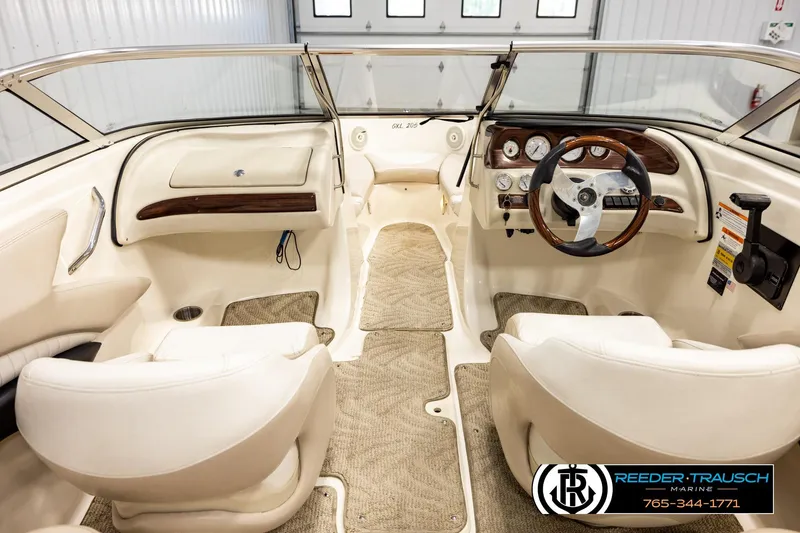 Slide: The Image of 2007 Glastron GXL 205 boat interior with beige seating and wood-accented dashboard. - 14
