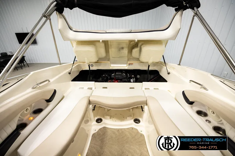 Slide: The Image of 2007 Glastron GXL 205 boat interior with open engine compartment, beige seating, and cup holders. - 21