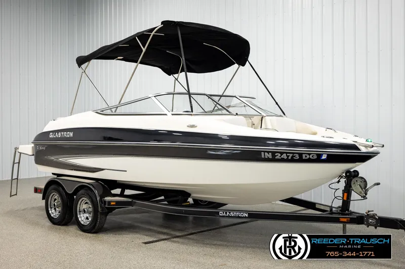 Slide: The Image of 2007 Glastron GXL 205 boat on trailer with black canopy in showroom. - 3