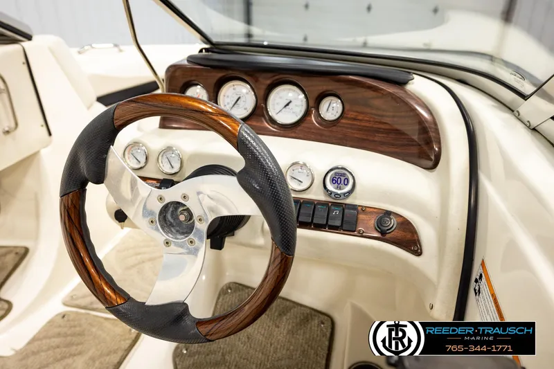 Slide: The Image of 2007 Glastron GXL 205 boat dashboard with wood-accented steering wheel and gauges. - 33