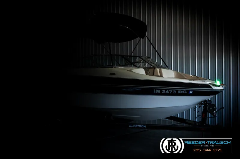 Slide: The Image of 2007 Glastron GXL 205 boat in dimly lit storage, showcasing sleek design and Reeder-Trausch Marine branding. - 4
