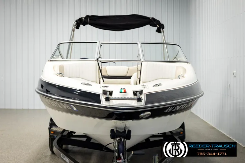 Slide: The Image of 2007 Glastron GXL 205 boat with black and white exterior in a showroom setting. - 8