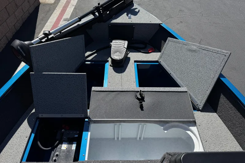 Slide: The Image of 2025 Lund 1650 Angler SS boat interior with open storage compartments and equipment. - 13