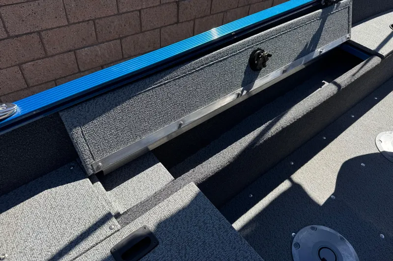 Slide: The Image of 2025 Lund 1650 Angler SS boat interior with textured flooring and storage compartment. - 18