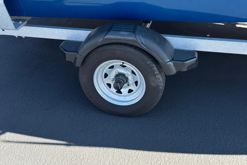 Slide: The Image of Trailer wheel of 2025 Lund 1650 Angler SS boat on asphalt surface. - 21