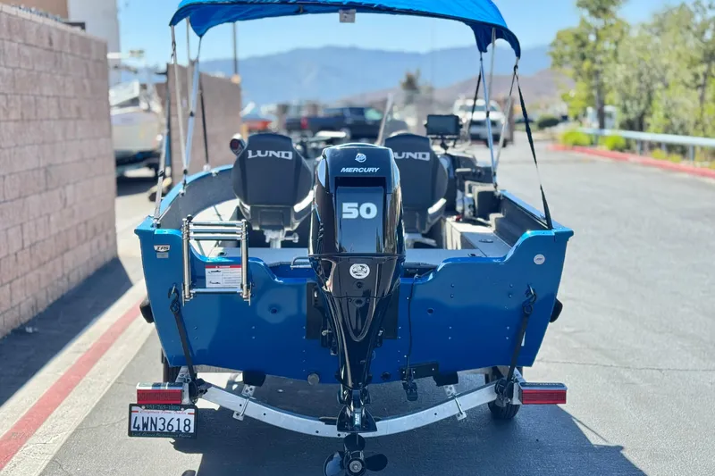 Slide: The Image of 2025 Lund 1650 Angler SS boat with Mercury 50 engine, parked on a trailer. - 4