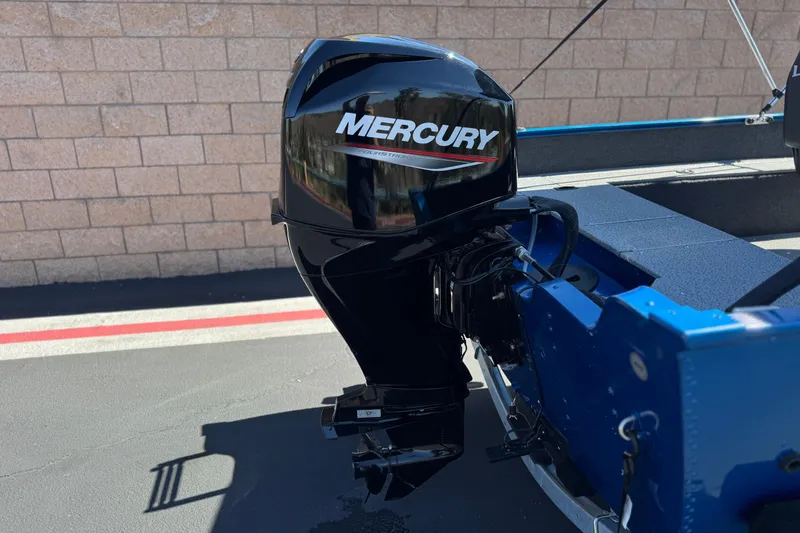 Slide: The Image of 2025 Lund 1650 Angler SS with Mercury outboard motor, parked on pavement. - 6