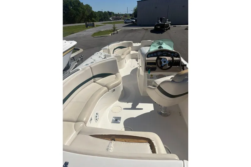 Slide: The Image of 2000 Chaparral Sunesta 232 boat interior with beige seating and steering console. - 5