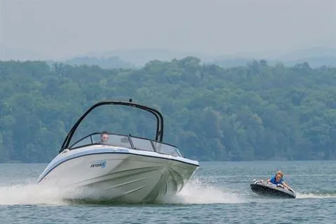 Slide: The Image of 2026 Yamaha Boats AR190 speeding on a lake, towing a person on an inflatable tube. - 8