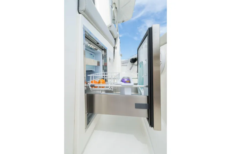 Slide: The Image of Open drawer refrigerator on 2026 Pursuit S 358 Sport boat, featuring oranges and a drink. - 11